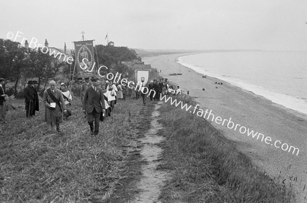 PROCESSION IN VILLAGE STREET ASCENDING CLIFF